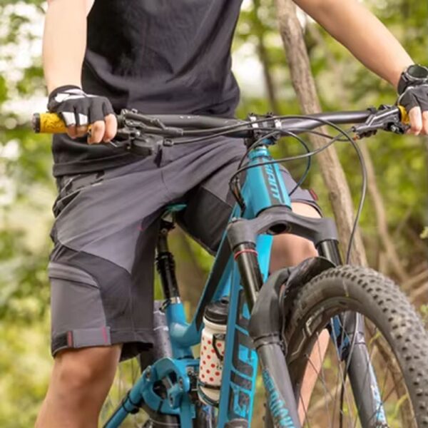 Ciclista con el short de ciclismo Rockbros YPK020 gris junto a una bicicleta MTB