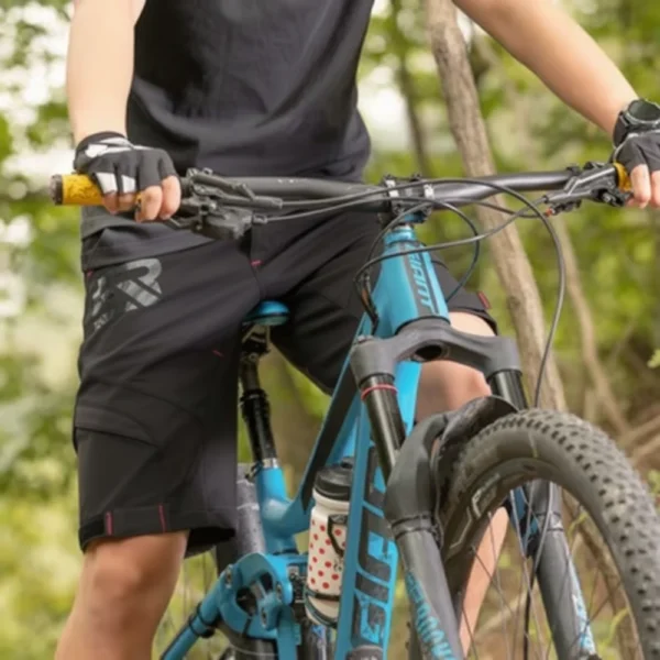 Ciclista con el short MTB Rockbros YPK020 negro junto a una bicicleta MTB