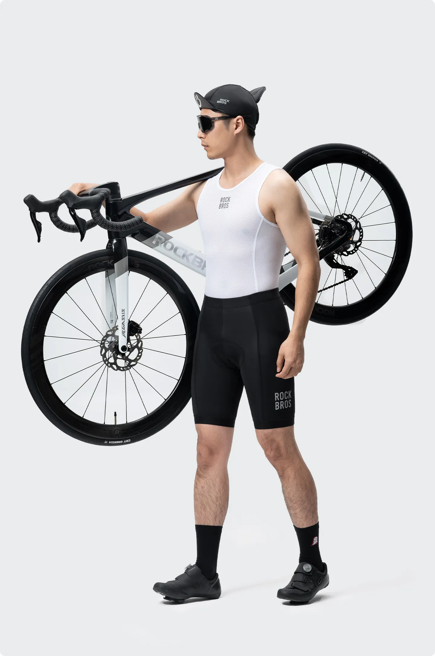 Ciclista con el culotte Rockbros YDDK001 negro cargando al hombro una bicicleta de ruta