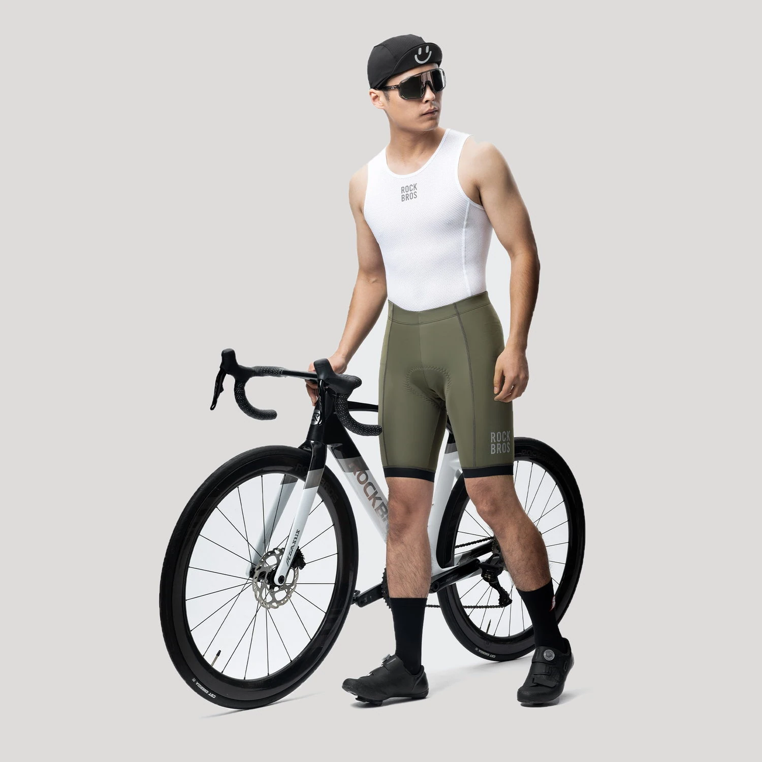 Ciclista con el culotte Rockbros YDDK001 verde oliva junto a una bicicleta de ruta