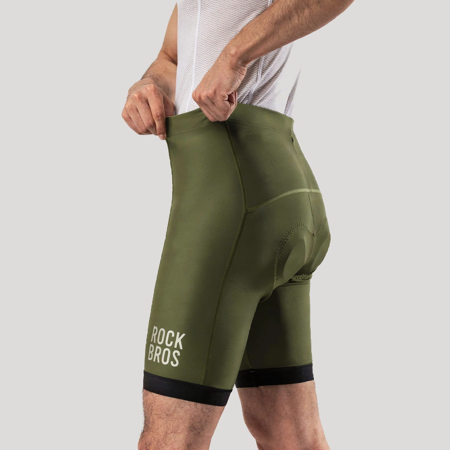 Manos estirando la pretina del culotte Rockbros YDDK001 verde oliva
