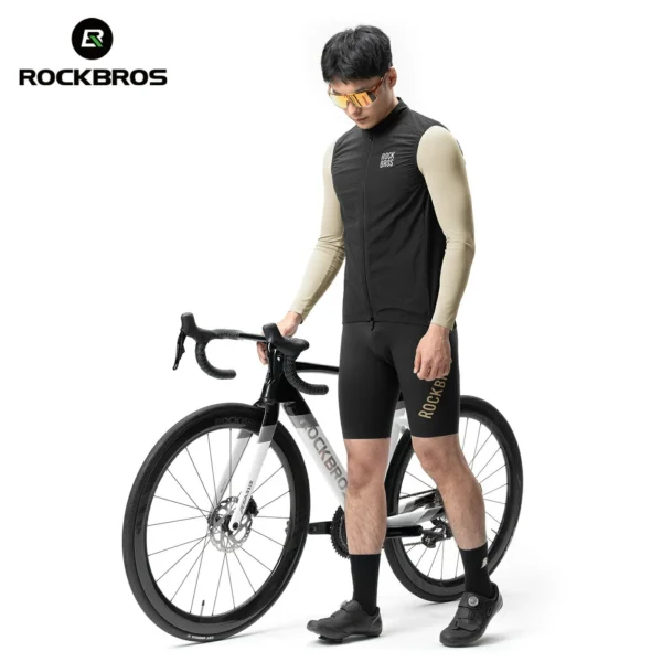 Ciclista con el chaleco Rockbros YDV3100 negro junto a una bici de ruta
